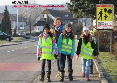 4 Kinder sind auf dem Weg zur Schule, sie tragen Sicherheitswesten