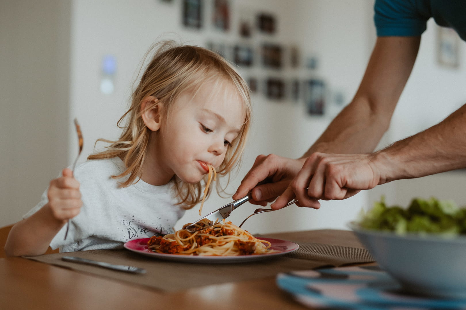 Familie ist Spaghetti für die Kinder zu schneiden