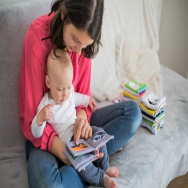 Mutter mit Baby ein Buch betrachtend