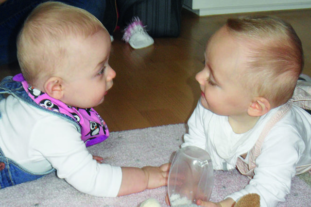 2 Babys liegen sich am Bauch gegenüber