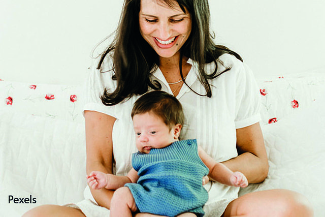 Frau mit Baby am Schoß